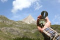 Man hand holding an orientation compass with beautiful mountain scenery on the background with copy space for your text Royalty Free Stock Photo