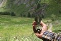 Man hand holding an orientation compass with beautiful mountain scenery on the background with copy space for your text Royalty Free Stock Photo