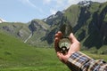 Man hand holding an orientation compass with beautiful mountain scenery on the background with copy space for your text Royalty Free Stock Photo