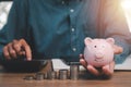 Man hand holding piggy bank with money stack step up growing growth on wood table Royalty Free Stock Photo