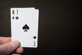 Man hand holding playing card ace and kind of spades isolated on black background with copyspace abstract Royalty Free Stock Photo