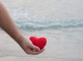 Man hand holding red heart on the beach Royalty Free Stock Photo