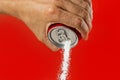 Man hand holding refresh drink can pouring sugar stream in sweet and calories content of soda and energy drinks Royalty Free Stock Photo