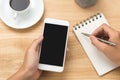 Man hand holding smart phone and pen with white blank empty screen on white desk table.Business concept. Royalty Free Stock Photo