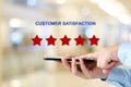 Man hand holding smart phone and red five star over blur background, customer excellent rating satisfacation, customer feedback