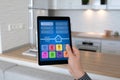 Man hand holding tablet app smart home background room kitchen Royalty Free Stock Photo