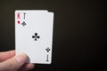 Man hand holding two playing card ace of clubs and and kind isolated on black background with copyspace Royalty Free Stock Photo
