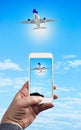 Man Hand holding using mobile phone and airplane on a blue background Royalty Free Stock Photo