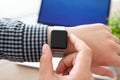 Man hand holding a Watch on the background of laptop Royalty Free Stock Photo