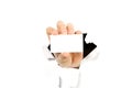 Man hand holding white business card thru hole in wall or broken white paper. mockup Royalty Free Stock Photo