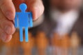 Man hand holds blue plastic human figurine closeup