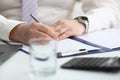 Man hand holds pen and fills out schedule of working day