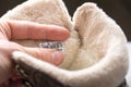 man hand holds size label on winter insulated fur shoe Royalty Free Stock Photo