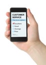 Man hand holds smart phone with customer service satisfaction survey Royalty Free Stock Photo