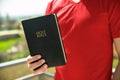 Man hand Holy Bible in nature Royalty Free Stock Photo