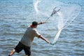 Man that Hand Launches the Fishnet at Sea on Blur Background Royalty Free Stock Photo