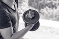 Man hand lifting the steel dumbbell in a gym muscle-building black and white image, life and fitness concept with copy space Royalty Free Stock Photo