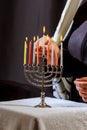 man hand lighting candles in menorah on table served for hanukka Royalty Free Stock Photo