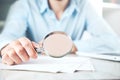 Man hand magnifier with document on desk