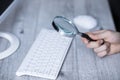 Man hand magnifier on keyboard