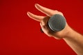 Man hand with microphone and devil horns over red Royalty Free Stock Photo