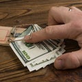 A man hand and a mousetrap with bait money dollars banknotes Royalty Free Stock Photo