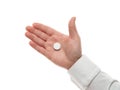 Man hand with one big white pill isolated on white background. White shirt, business style. Medicament and food supplement for Royalty Free Stock Photo