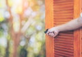 Man hand open door Handle the rocking shaft or opens empty room door to nature and yellow flower field and blue sky. Royalty Free Stock Photo