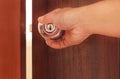 Man hand opening the door, brown wooden door with metal handle Royalty Free Stock Photo