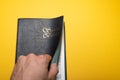 Man hand opening Santa Biblia Holy Bible in spanish on yellow Royalty Free Stock Photo