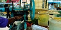 Man hand operating sugarcane juice grinding machine at market in India aug 2019