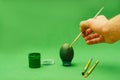 Man hand paints Easter egg with brush Royalty Free Stock Photo