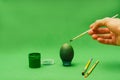 Man hand paints Easter egg with brush Royalty Free Stock Photo