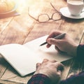 Man hand with pen writing on notebook on wooden table Royalty Free Stock Photo