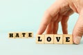 Man hand picking wooden cubes with the text LOVE and HATE Royalty Free Stock Photo