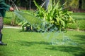 Garden man hand pouring grass with the water tap