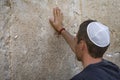 Man hand and pray paper on the Western Wall, Wailing Wall the Place of Weeping is an ancient limestone wall in the Old City of