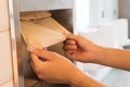 Man hand pulling a brown tissue from tissue box in the restroom.