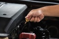 Man hand pulling oil gauge stick up for checking level of motor oil lubricant in the engine, car maintenance service