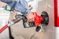 Man hand pumping gasoline with insect on car lights