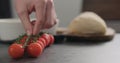 Man hand put cherry tomatoes branch on conrete countertop Royalty Free Stock Photo