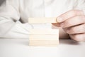 Man hand put wooden blocks in the shape of a staircase isolated on white background with copy space. Concept of building success Royalty Free Stock Photo