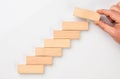 Man hand put wooden blocks in the shape of a staircase Royalty Free Stock Photo