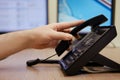 A man hand puts a telephone receiver at the monitors of office computers. Ending a telephone conversation at the workplace, table Royalty Free Stock Photo