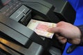 Man hand putting banknotes in the receiver of the cash recycler, closeup