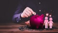 Man hand putting golden money coin into blue piggy bank for saving money. Royalty Free Stock Photo