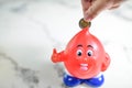 Man hand putting money coin into piggy bank for saving money weal Royalty Free Stock Photo