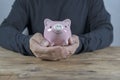 Man hand putting money coin into piggy for saving money wealth Royalty Free Stock Photo