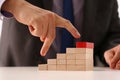 Man hand raises fingers up a wooden staircase made of wooden blocks Royalty Free Stock Photo