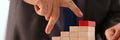 Man hand raises fingers up a wooden staircase made of wooden blocks Royalty Free Stock Photo